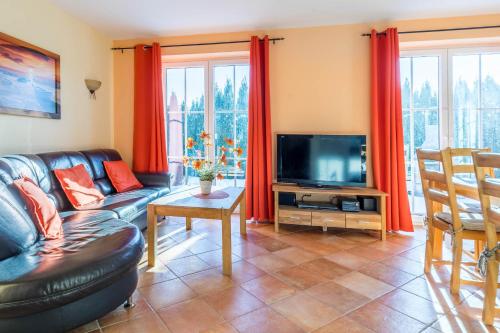 a living room with a couch and a tv at Ferienhaus Sandra in Wohlenberg