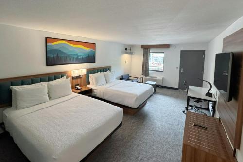 a hotel room with two beds and a television at Howard Johnson by Wyndham Downtown Gatlinburg in Gatlinburg