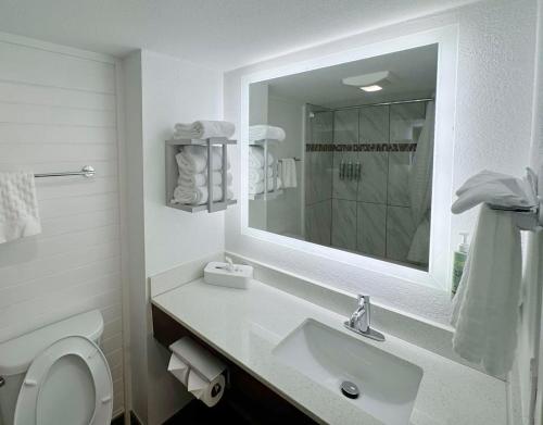a white bathroom with a sink and a mirror at Howard Johnson by Wyndham Downtown Gatlinburg in Gatlinburg