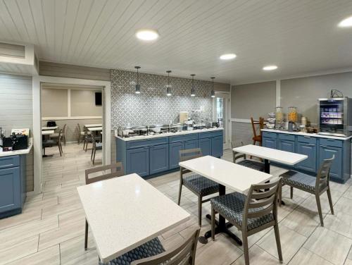 a kitchen with blue cabinets and tables and chairs at Best Western Johnson's Inn Downtown Gatlinburg in Gatlinburg