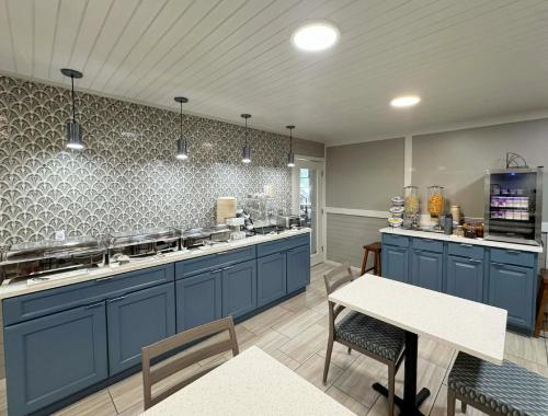 a large kitchen with blue cabinets and a table at Howard Johnson by Wyndham Downtown Gatlinburg in Gatlinburg