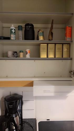 a shelf in a kitchen with a coffee maker at Station Stay Örebro in Örebro