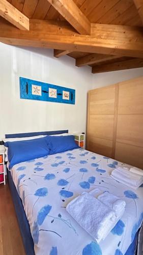 a bedroom with a bed with blue flowers on it at Casa Candiotty Lake & Mountain in Endine Gaiano