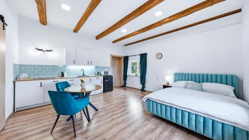a bedroom with a bed and a table and a kitchen at Penzion Pod Vinicemi in Litoměřice
