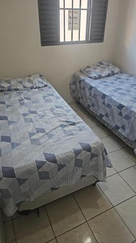 two beds sitting next to each other in a room at Apartamento Simples em Teresina com 02 Quartos in Teresina