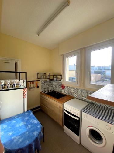 a kitchen with a refrigerator and a stove top oven at Splendide, FACE MER avec place de parking PRIVEE in Berck-sur-Mer