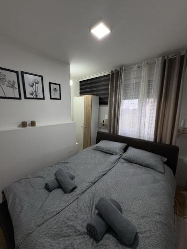 a bedroom with a large bed with two pillows at City Vibes in Subotica