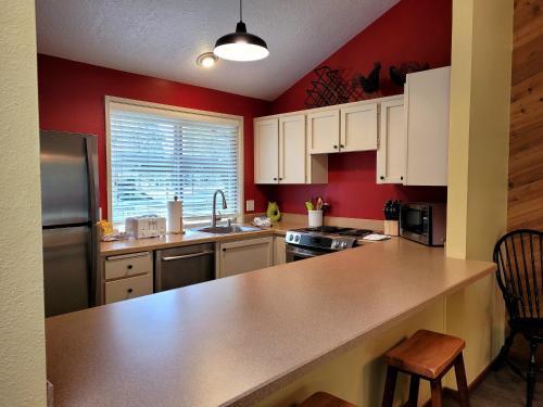 a kitchen with red walls and a counter top at 3 Quelah Condo in Sunriver