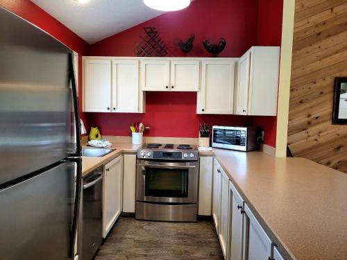 a kitchen with red walls and white cabinets at 3 Quelah Condo in Sunriver