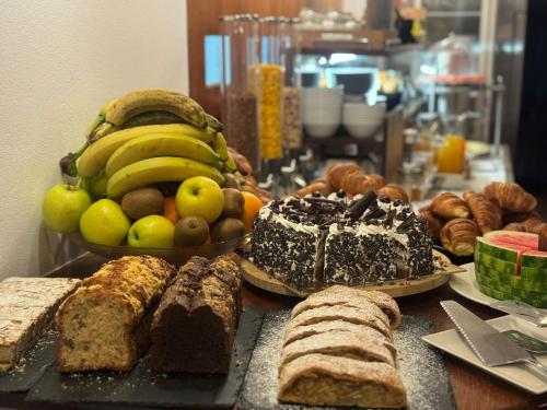 a table topped with lots of different types of bread and fruit at Hotel Cavallino s'Rössl in Merano