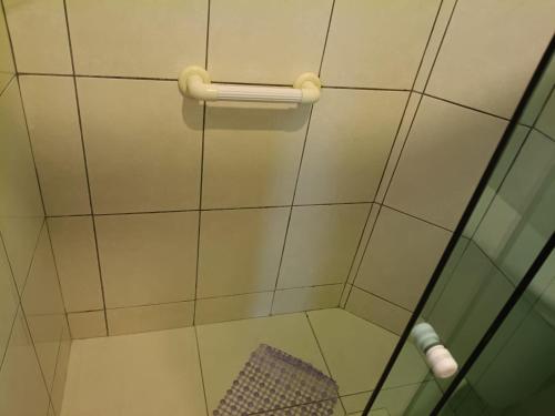 a shower with a glass door and a towel at Pousada Em-Cantto in Conservatória