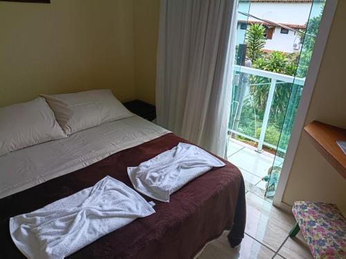 a bed in a room with a large window at Pousada Em-Cantto in Conservatória