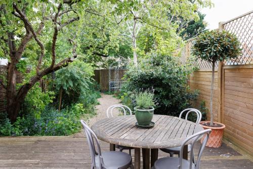 a wooden table and chairs on a patio at Stylish, Spacious, Oxford Townhouse, Driveway parking in Oxford