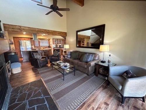 a living room with a couch and chairs and a mirror at 32 Meadow House in Sunriver