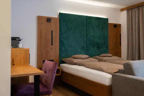 a bedroom with two beds with a green headboard at Zenger Hotel in Offenberg