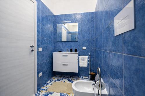 a blue tiled bathroom with a sink and a toilet at Fantasy House Suites in Forio d'Ischia