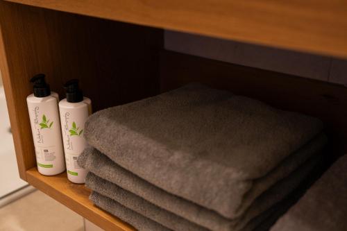 two bottles of lotion and towels on a shelf at Zenger Hotel in Offenberg
