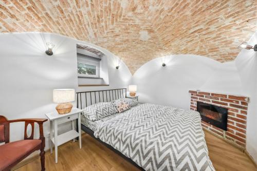 a bedroom with a bed and a brick wall at Penzion Pod Vinicemi in Litoměřice