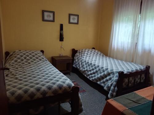 two beds sitting in a room with a window at Quimelco casa de campo in La Granja