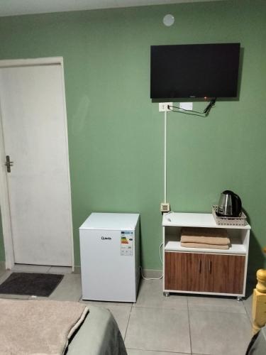 a room with a television on a green wall at BM Apart-Alojamiento in Ciudad del Este