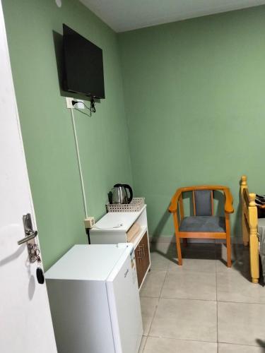 a kitchen with a refrigerator and a table and a chair at BM Apart-Alojamiento in Ciudad del Este