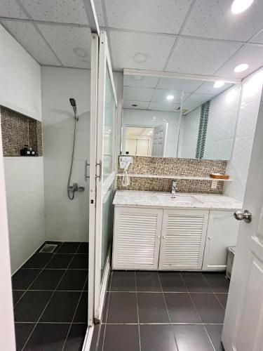 a bathroom with a shower and a sink and a mirror at KT SG Hotel - Center in Ho Chi Minh City