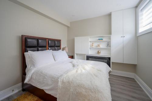 a bedroom with a large bed with white sheets at Beach House First Floor in Pickering