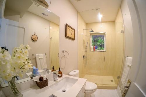 a bathroom with a shower and a toilet and a sink at Beach House First Floor in Pickering