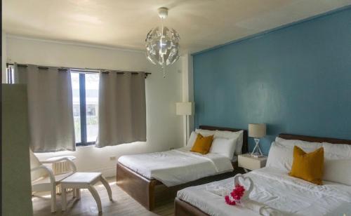 a bedroom with two beds and a chandelier at Virmuda Villa Rental in Po-oc