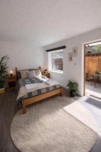 a bedroom with a bed and a large window at Entire Apartment Bright & Spacious with Private Garden Near Victoria Park in London