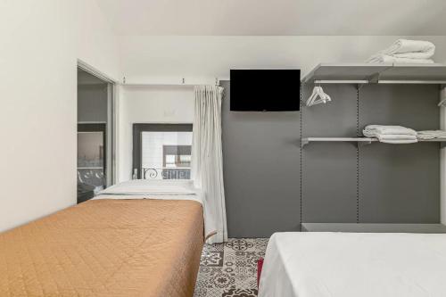 a room with two beds and a tv in it at Gaias Rooms in Olbia
