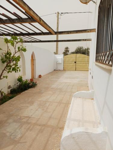 an empty patio with a bench in a building at Djerba Beach Haven in Aghīr