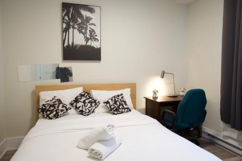 a bedroom with a bed with a desk and a chair at Cozy stays in Montreal