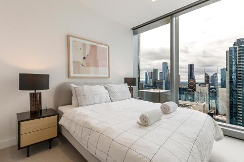 a bedroom with a white bed and a large window at Spencer on Rock in Melbourne