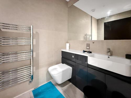a bathroom with a toilet and a sink at Luxury Apartments in Milton Keynes
