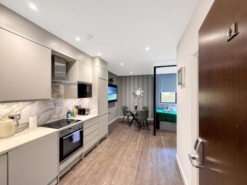 a kitchen with a sink and a table in a room at Luxury Apartments in Milton Keynes