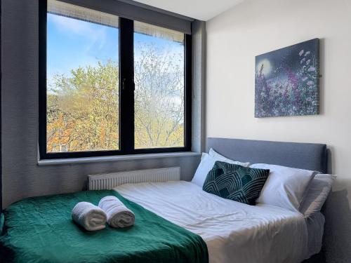 a bedroom with a bed with two towels on it at Luxury Apartments in Milton Keynes