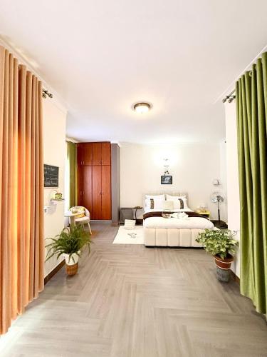 a bedroom with a large bed and green curtains at The Reset Stay in Kampala