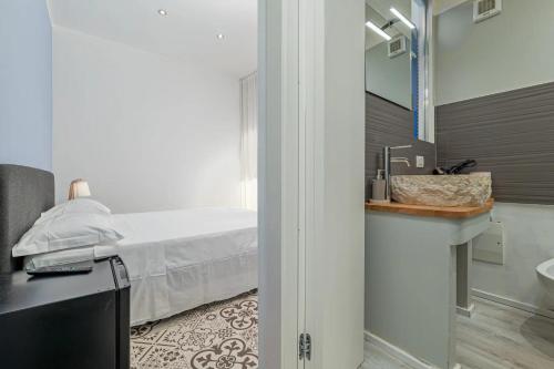 a bedroom with a bed and a bathroom with a sink at Gaias Rooms in Olbia
