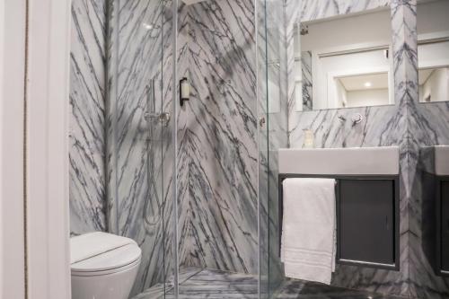 a bathroom with a shower and a toilet and a mirror at RS Porto Central Apartments in Porto