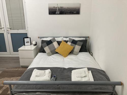 a bedroom with a bed with a yellow pillow at Thames Riverside Studio, Gravesend Town Centre - near train station in Gravesend