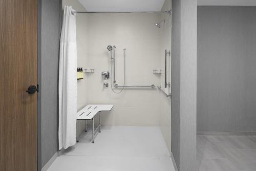 a bathroom with a shower and a table in it at Hyatt Place Bozeman Yellowstone Airport in Belgrade