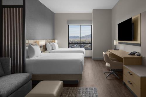 a hotel room with two beds and a desk at Hyatt Place Bozeman Yellowstone Airport in Belgrade