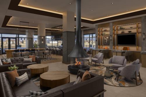 a lobby with couches and a fireplace and a bar at Hyatt Place Bozeman Yellowstone Airport in Belgrade