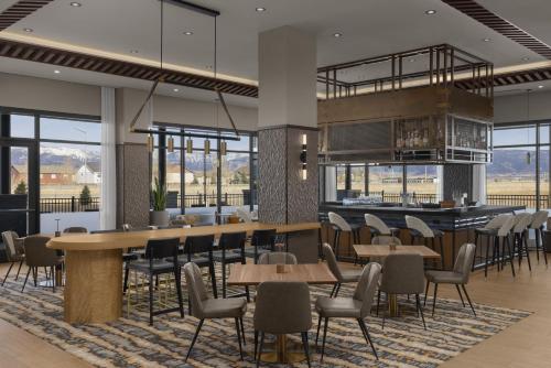 a rendering of a restaurant with tables and chairs at Hyatt Place Bozeman Yellowstone Airport in Belgrade