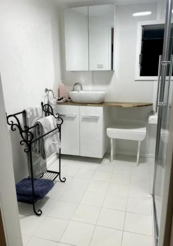 a white bathroom with a sink and a toilet at The Haven in Blackall