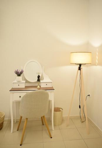 ein Schreibtisch mit Stuhl, Spiegel und Lampe in der Unterkunft Chatzidakeio View Apartments in Xánthi