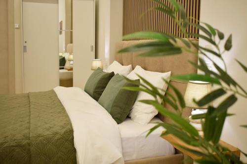 ein Schlafzimmer mit einem Bett mit grünen und weißen Kissen in der Unterkunft Chatzidakeio View Apartments in Xánthi