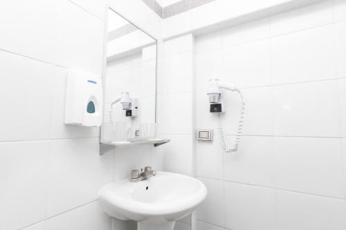 a white bathroom with a sink and a mirror at Casa Andina Standard Cusco Catedral in Cusco