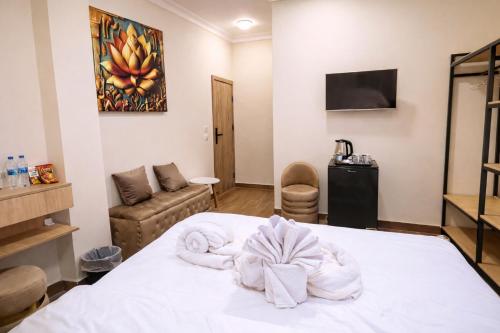 a room with a bed with towels on it at The 5 Inn - Rooftop Pyramids View in Cairo